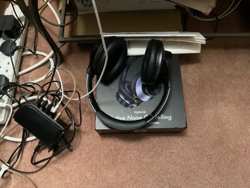 Černá sluchátka Oneodio vedle domácí audio sestavy